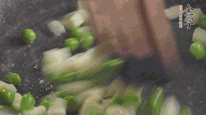 鍋中油7成熱時(shí)，入青豆、筍丁翻炒，然后加糯米飯加鹽均勻翻炒。