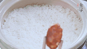 煮開后轉小火，當米飯出現(xiàn)小孔時，鋪上金字麻辣香腸。