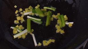 鍋中熱油，依次下姜粒、蔥段、蘆筍炒香。