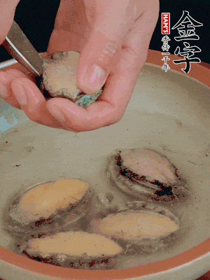 鮑魚加鹽、清水浸泡，用勺子挖出鮑魚肉。