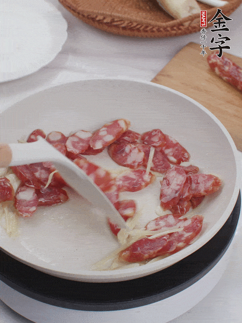 油溫3成熱時(shí)，下姜絲、蒜片、香腸炒出油脂。