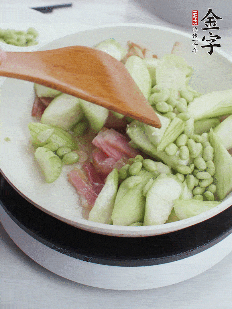 依次下絲瓜、青豆翻炒，炒至絲瓜打蔫縮小。