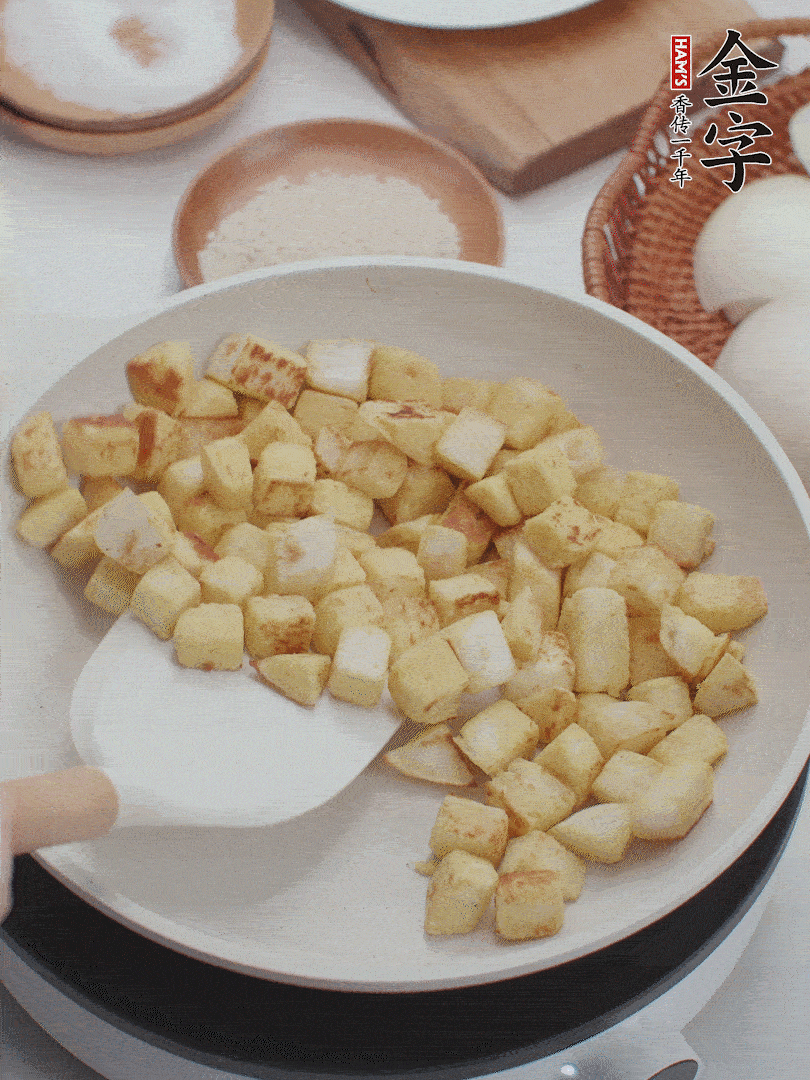 起鍋熱油，倒入饅頭丁，小火煎至蛋液凝固定型再翻面，饅頭丁部煎至金黃時盛起待用。
