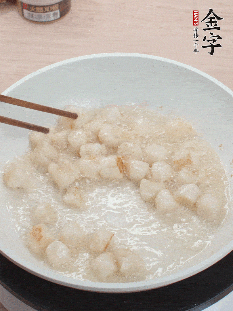 油溫4成熱，鮮貝蘸干淀粉下鍋煎，一面微黃后翻面。