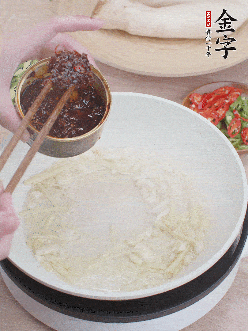 起鍋熱油，姜蒜、金字火腿干貝醬煸香。