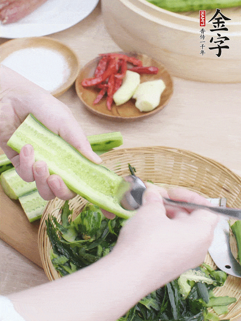 黃瓜削皮，對半切開，勺子挖去內(nèi)瓤，斜刀切片。青蒜斜刀切段。