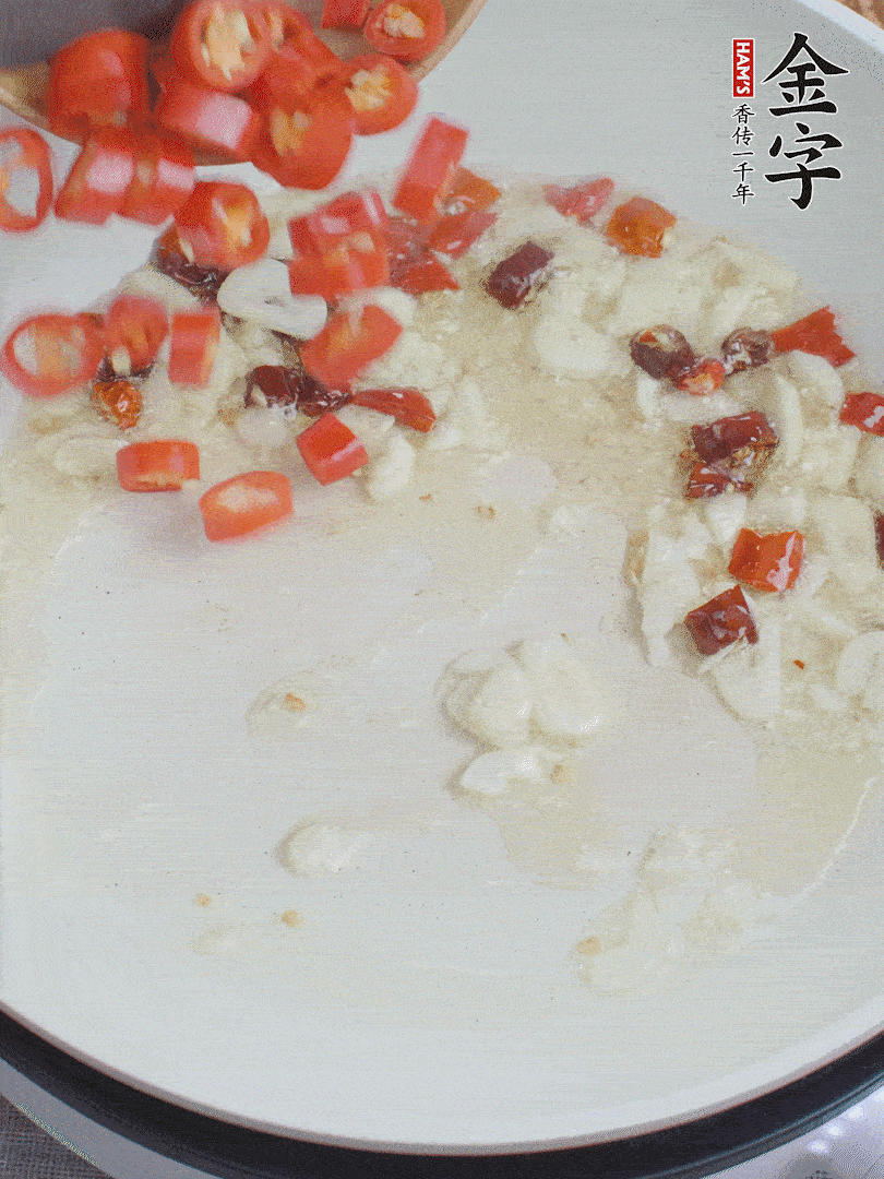 油6成熱，下蒜末、干紅辣椒煸炒，出香味后再放美人椒、香腸。