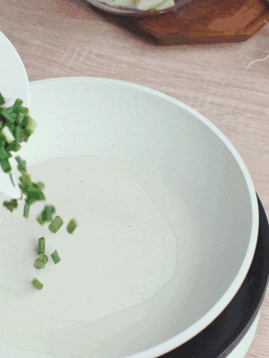 熱油下臘肉、蔥花煸炒，再下西葫蘆。