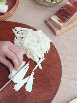 茭白切細(xì)絲，鹽水中浸泡防止氧化。