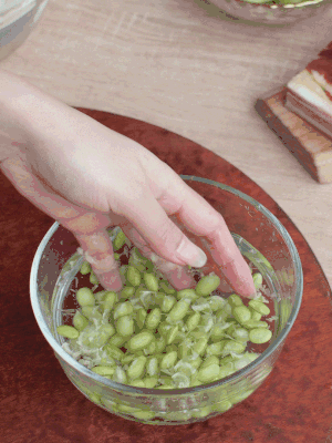 青豆剝殼，搓去外衣。