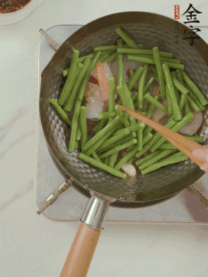 下掰好的缸豆段翻炒，略燜煮。