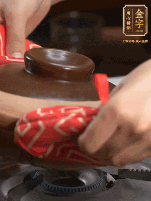 中火調(diào)成小火，鋪上香腸蓋蓋燜5分鐘。不斷轉(zhuǎn)動瓦煲，讓側(cè)壁的飯形成飯焦