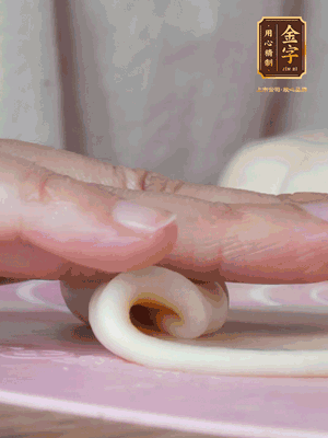 做面劑 油皮按扁，中間包入一個(gè)油酥，邊緣收緊捏死。包好的面劑按扁，用搟面杖搟壓成橢圓形。從底部向上卷成筒狀，用保鮮膜蓋好松弛15分鐘，再把筒狀縱向搟壓成長(zhǎng)條狀。再卷一次，松弛20分鐘