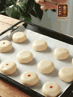 收口向下放在案板上，輕輕將月餅坯按扁，用筷子點(diǎn)紅點(diǎn)做裝飾