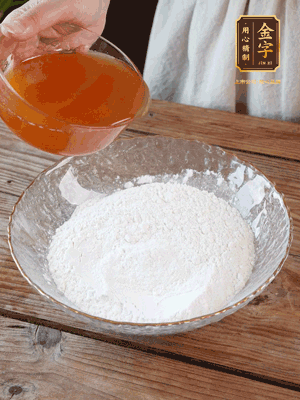 轉(zhuǎn)化糖漿、枧水、花生油攪拌均勻，加入面粉混合，醒發(fā)2小時。捏成23g一個的小球