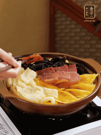 砂鍋底部鋪上娃娃菜，依次擺上肉皮、蛋餃、黑木耳、火腿