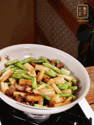 油熱下蒜末、干辣椒、醬肉煸炒出香味，依次下藕條、豆角翻炒均勻